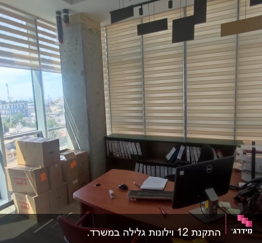 וילונות גלילה בהירים על חלונות משרד
